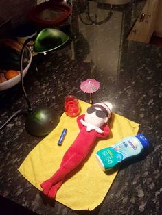 a towel, toothpaste and sunscreen are on the counter top next to an elf doll