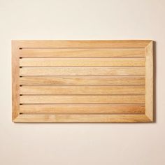 a wooden cutting board on a white wall