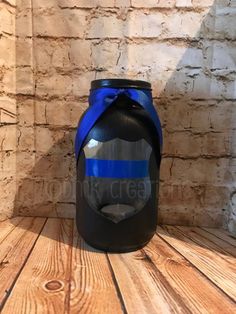 a black and blue canister sitting on top of a wooden table next to a brick wall