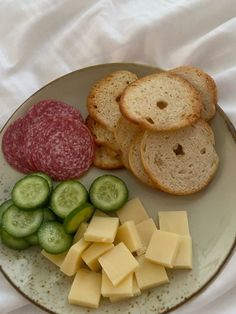 a plate with bread, cheese and pickles on it