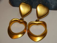 "The earrings are gold-tone metal featuring two hearts, size 2.5\" inches tall x 1 1/4\" inch wide, weight 33.8 grams in excellent condition." Gold Double Heart Metal Earrings, Gold Metal Double Heart Earrings, Gold Clip-on Heart Earrings For Valentine's Day, Vintage Gold Heart Earrings For Party, Gold Heart-shaped Clip-on Earrings, Vintage Gold Double Heart Earrings, Gold Double Heart Vintage Earrings, Swan Logo, Swarovski Crystal Bracelet