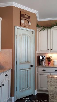 a kitchen with white cabinets and brown walls