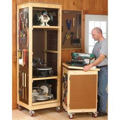 a man standing next to a cabinet with tools in it and working on the workbench