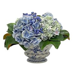 a blue and white vase filled with lots of flowers