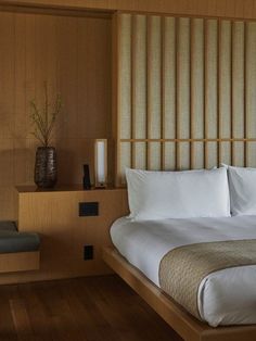 a large bed sitting in a bedroom next to a wooden wall