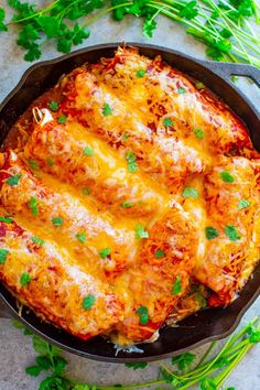 a skillet filled with cheesy lasagna covered in cheese and parsley