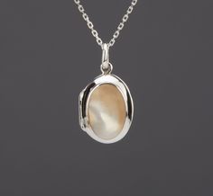 An oval sterling silver photo locket necklace with an oval bezeled mother of pearl on the front: 1. One shining, highly polished solid sterling silver locket, 19 x 14 x 7.6 mm (measured without the bale) and weighs 3.4 grams Its front has a piece of mother of pearl (16 x 11 mm) set in a raised bezel. Its back is plain and can be engraved with initials or a few words. 2. It has two photo slots insides. Photo insertion service available (selected through the pulldown menu). If you choose this serv Locket Necklace Silver, Picture Locket, Valentine Gifts For Girlfriend, Photo Locket Necklace, Sterling Silver Locket, Oval Locket, Memory Locket, Silver Locket, Photo Locket