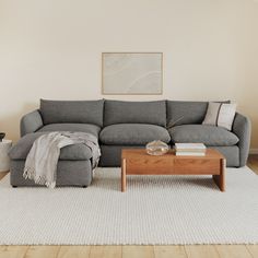 a living room with a gray couch and coffee table in front of the sectional sofa