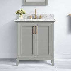 a bathroom vanity with marble top and two gold faucets on the sink area