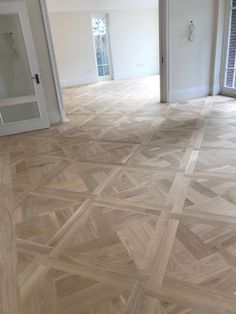 an empty room with wooden floors and doors