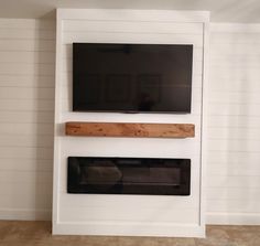 a flat screen tv mounted to the side of a wall next to a fire place