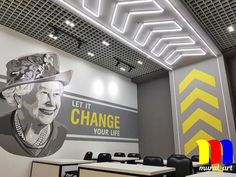 an office with a large mural on the wall that says let it change your life