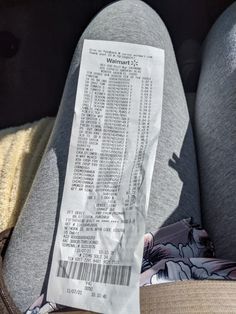 a receipt sitting on the back of someone's leg in their car seat,