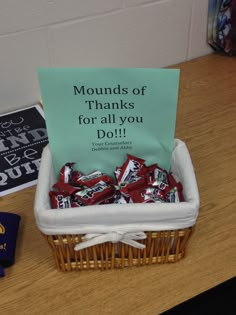 a basket filled with lots of candy sitting on top of a table next to a sign