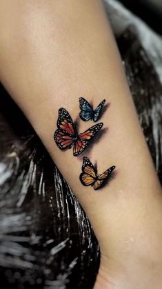 three butterflies tattoo on the left ankle and right leg, with one butterfly flying in the air