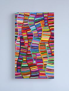 an abstract painting with multicolored wavy lines on it's surface, against a white wall