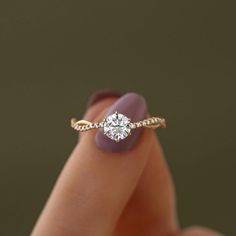 a woman's hand with a diamond ring on top of her finger, showing the side view