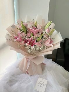 a bouquet of pink flowers sitting on top of a white table next to a mirror