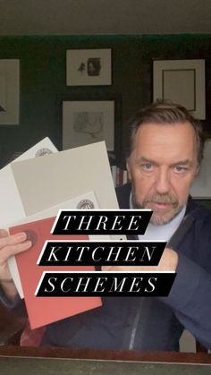 a man in a suit holding up some papers with the words three kitchen schemes on it