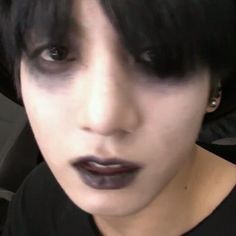 a woman with black hair and dark makeup