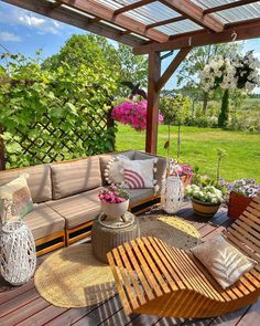 an outdoor living area with wooden furniture and flowers