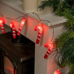 christmas lights are hanging on the mantle next to a fireplace