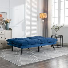 a blue couch sitting on top of a rug in a living room