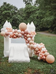 an arch made out of balloons in the grass