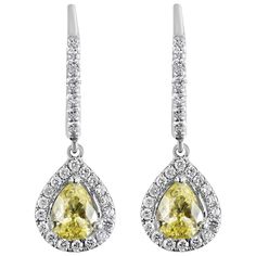 Color-rich pear-shaped yellow diamonds take the spotlight in this magnificent dangle earrings. Each yellow diamond is surrounded by a single row of sparkling round diamonds attached to an accented 18 karat white gold french hook. Yellow diamonds weigh 0.86 carats total while the accent diamonds weigh 0.50 carats total. Style available in different price ranges. Prices are based on your selection of the 4C’s (Carat, Color, Clarity, Cut). Please contact us for more information.