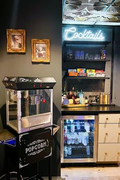 a small bar with an ice chest in front of it and pictures on the wall