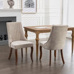 a dining room table with two chairs and a fireplace in the backround area