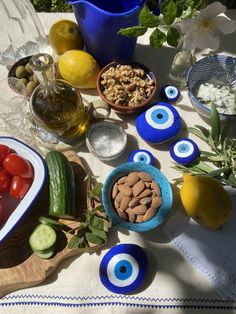 a table topped with bowls filled with different types of vegetables and fruits next to an eye shaped bowl