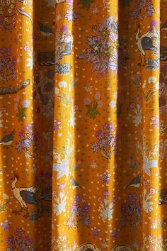 an orange curtain with birds and flowers on it