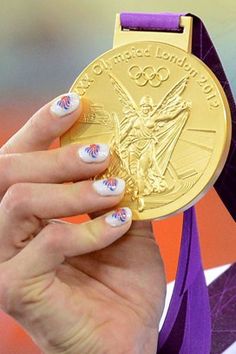 a close up of a person holding a gold medal