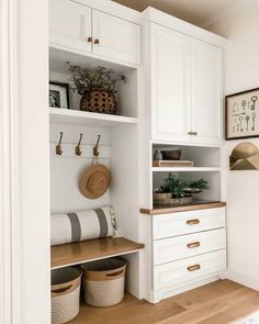 a kitchen with white cabinets and wooden floors