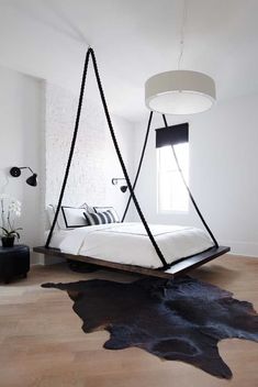 a bed with black and white decor in a modern style bedroom, hanging from the ceiling