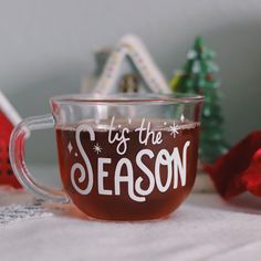 a glass mug that says tis the season on it