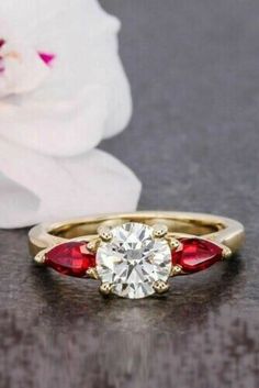 a close up of a ring with a flower in the background