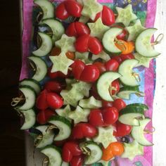 cucumbers, tomatoes, and other vegetables are arranged on a table cloth for display