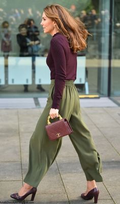 a woman walking down the street carrying a purse