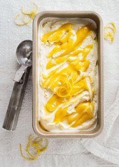 an ice cream dish with lemon drizzled on top and spoon next to it