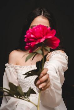 a woman holding a flower in her hands