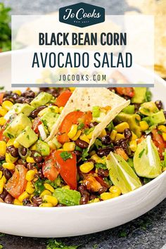 black bean corn avocado salad in a white bowl with tortilla chips