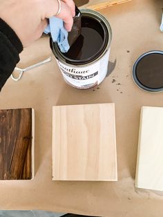 someone is painting wood with brown paint on the table next to some other pieces of wood