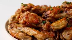 a white bowl filled with chicken wings covered in sauce