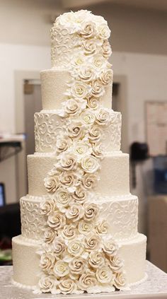 a large white wedding cake with flowers on it