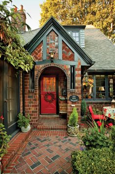 a brick house with green trim and red door