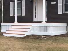 a porch with steps leading up to the front door and windows on top of it