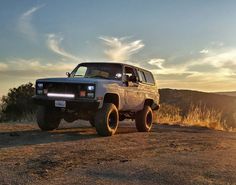 a truck parked on the side of a dirt road