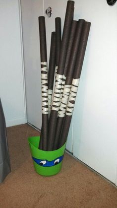 a green bucket filled with black and white sticks